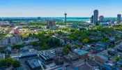 Drone image of City of Niagara Falls skyline with buildings and blue sky.